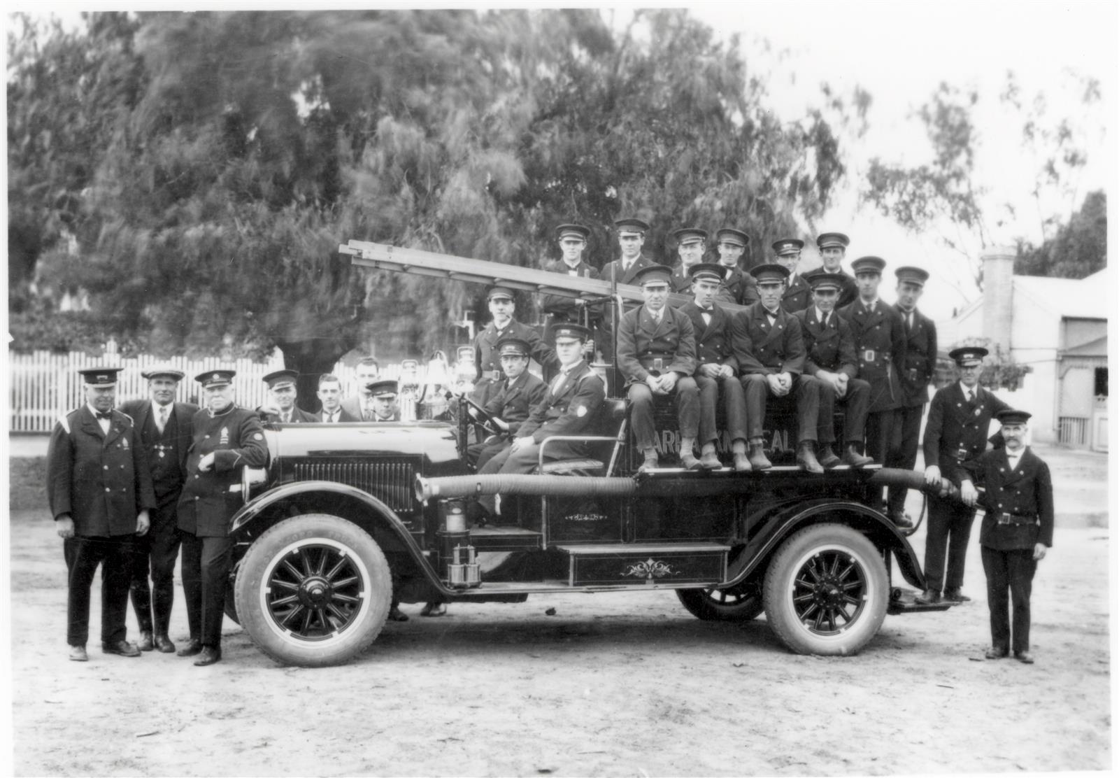 REO 6 pumper. L-R in front of pumper: Captain Tom Gardiner, Mechanic Jack Trengrove and Chief Officer W. Chellew